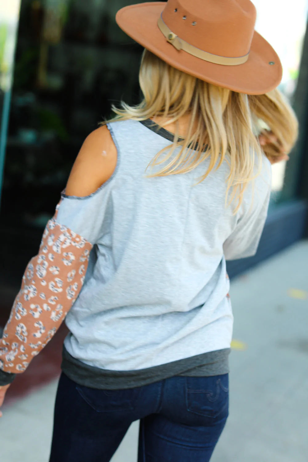 Back view,  animal print top with one cut out shoulder.