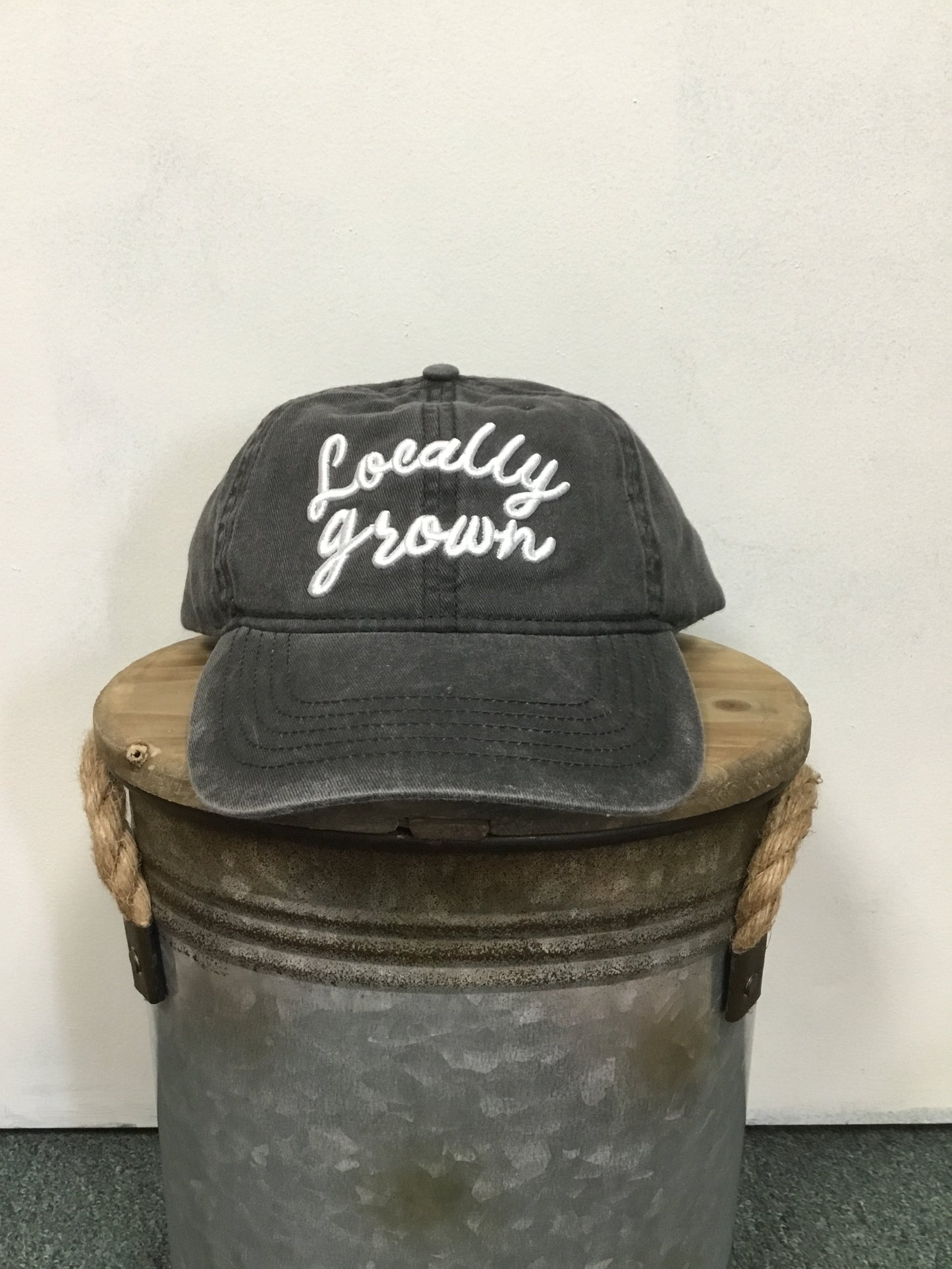 Locally Grown on the front of the Hat. Color Black.