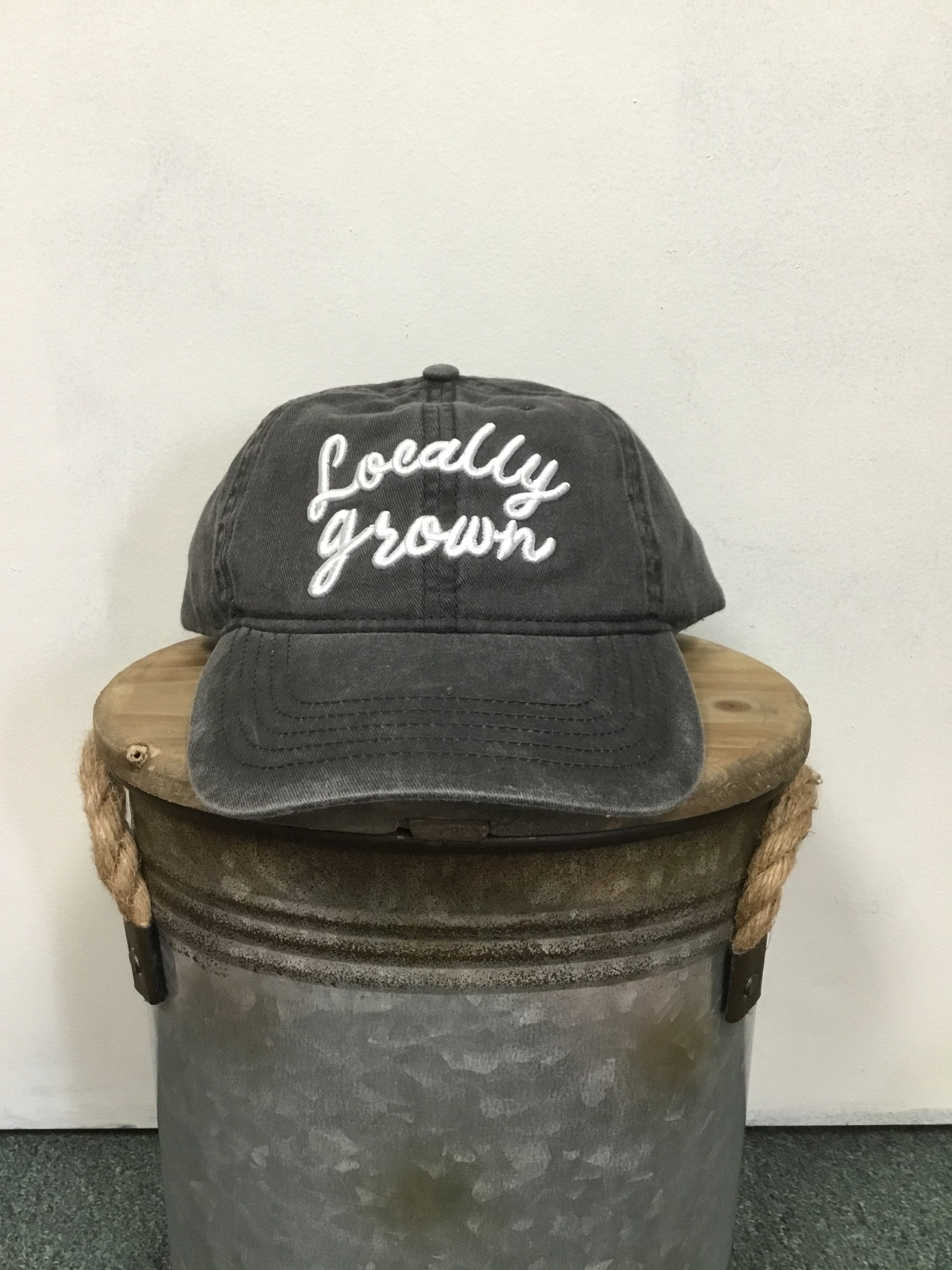 Locally Grown on the front of the Hat. Color Black.